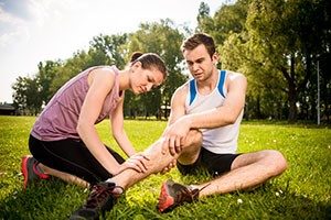 Woman helping man with sports injury